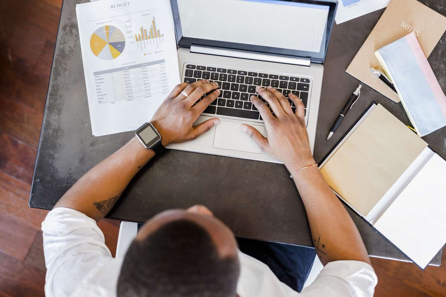 Person reading financial planning materials on laptop